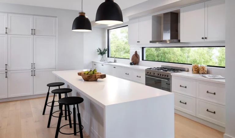 Modern kitchen with white particle board cabinets and a large island countertop