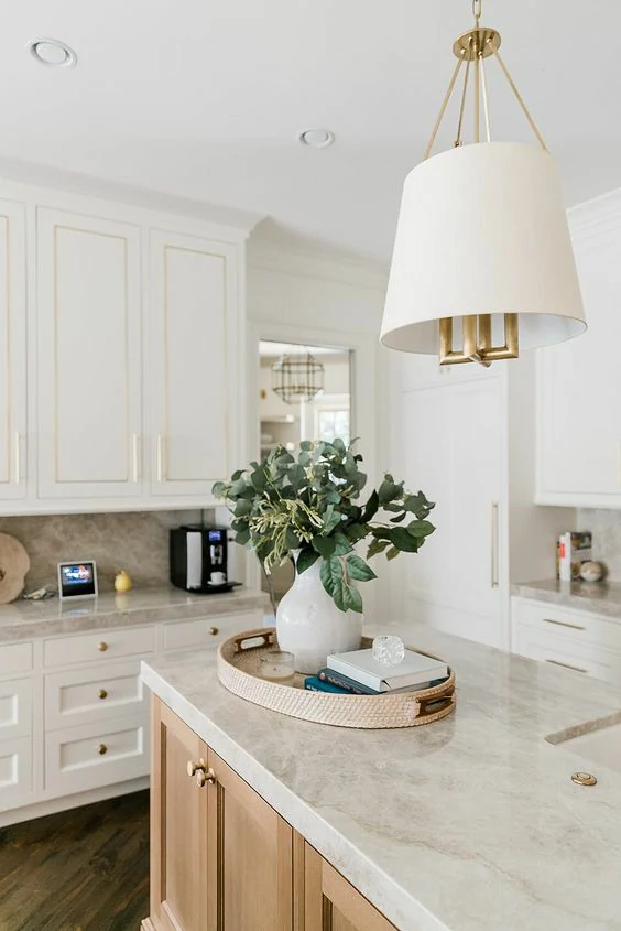 Elegant kitchen with a modern countertop, featuring white cabinetry and a stylish decorative tray.