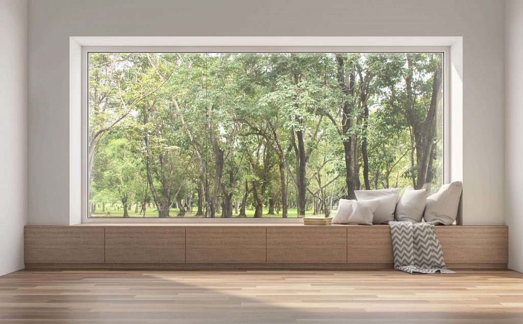 Expansive aluminum-framed picture window showcasing an outdoor nature view with trees.