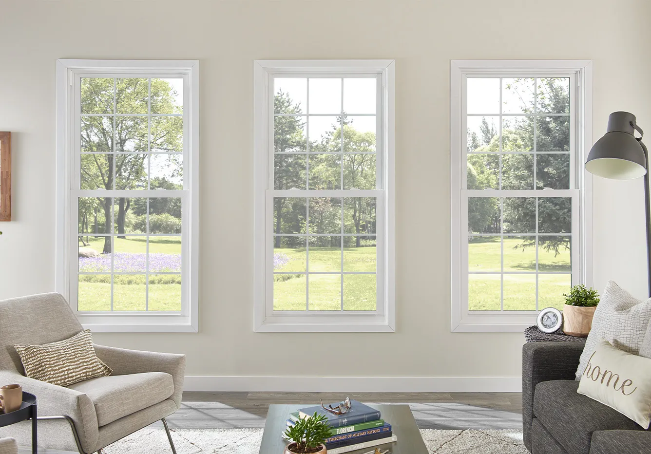 Three white aluminum double-hung windows in a bright living room with a modern aesthetic.