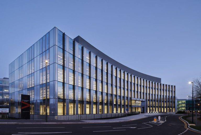 Modern office building under construction with glass facades and flexible workspace design.