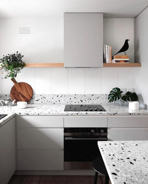 Greige kitchen cabinets with terrazzo countertops, open shelving, and minimalist decor for a stylish modern design