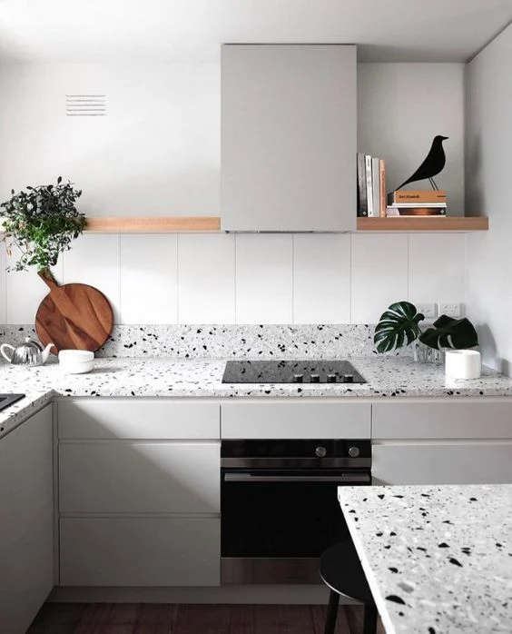 25 ideas inspiradoras de gabinetes de cocina en tonos greige para realzar tu hogar 22 Gabinetes de cocina en color greige con encimeras de terrazo, estantes abiertos y decoración minimalista para un diseño moderno y elegante.