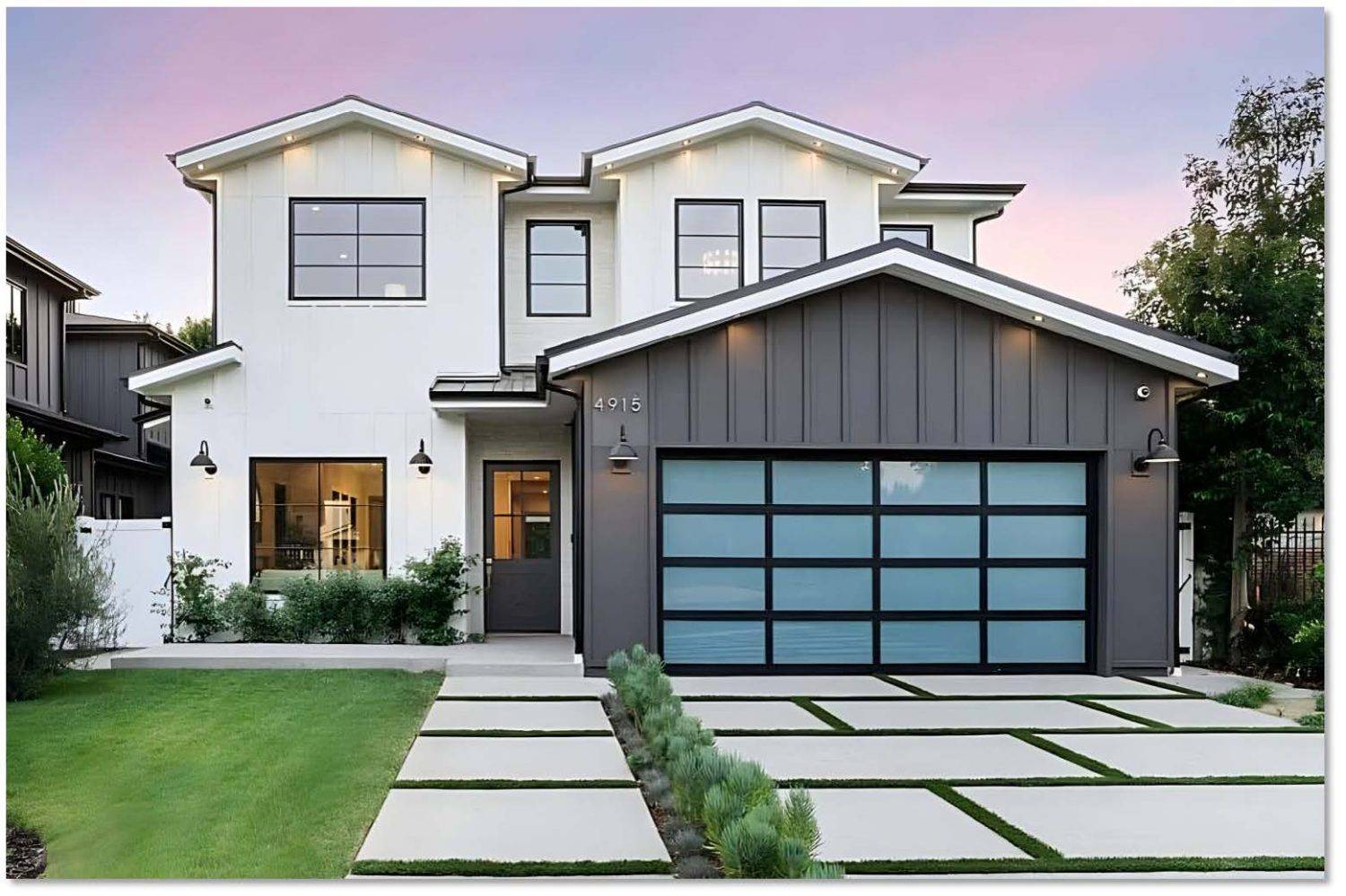 Modern home exterior featuring a fashionable and durable garage door with sleek black frames and large glass panels, complemented by landscaped pathways.