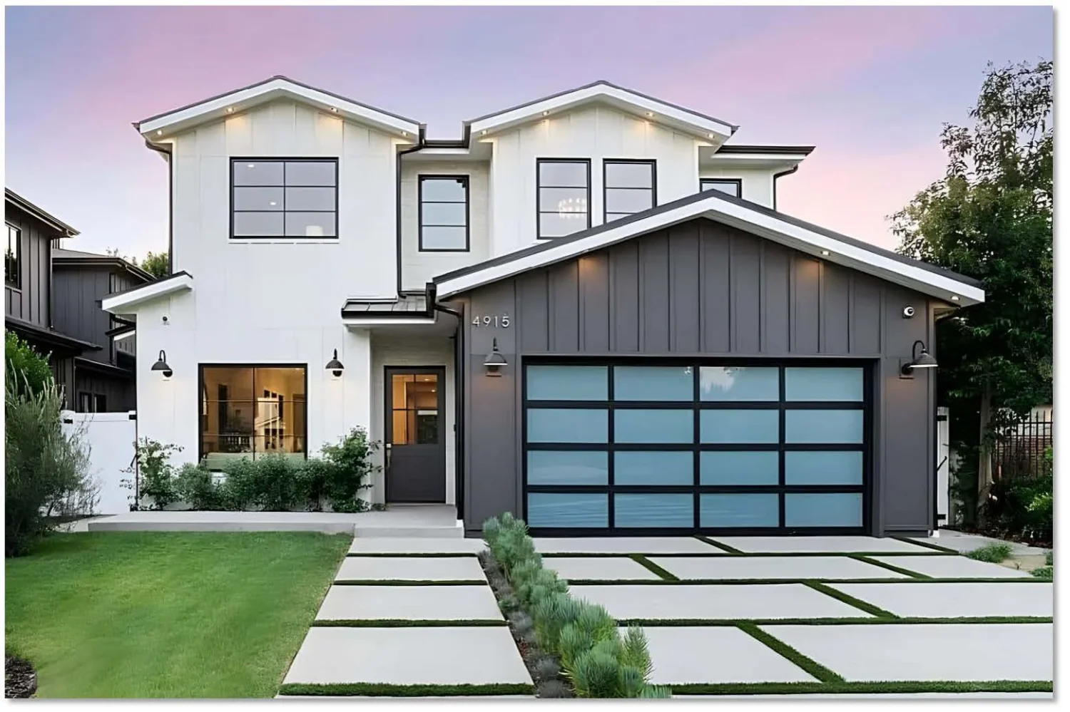 Modern home exterior featuring a fashionable and durable garage door with sleek black frames and large glass panels, complemented by landscaped pathways.