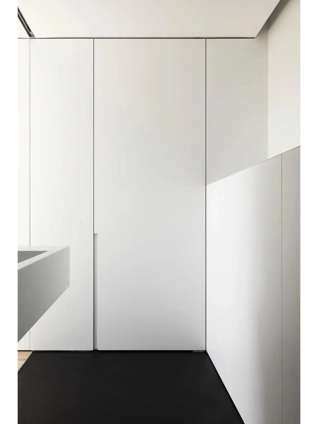 White invisible interior door with a seamless flush design, blending effortlessly into a modern minimalist space for a clean and sophisticated look.