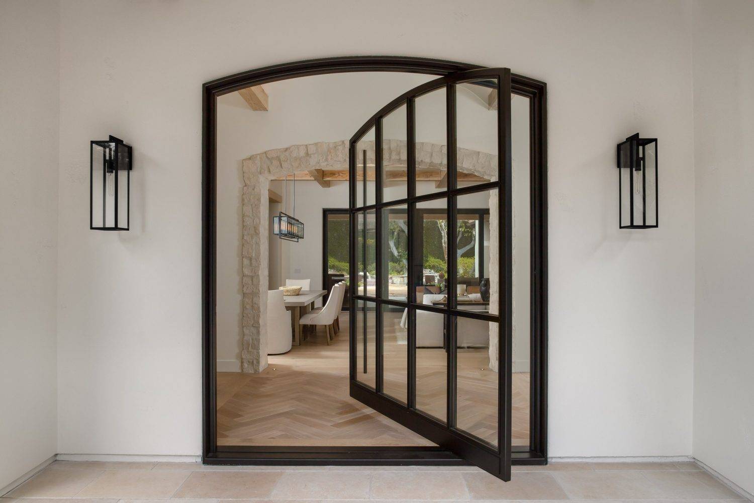 arched black-aluminum-pivot-door-with-grids