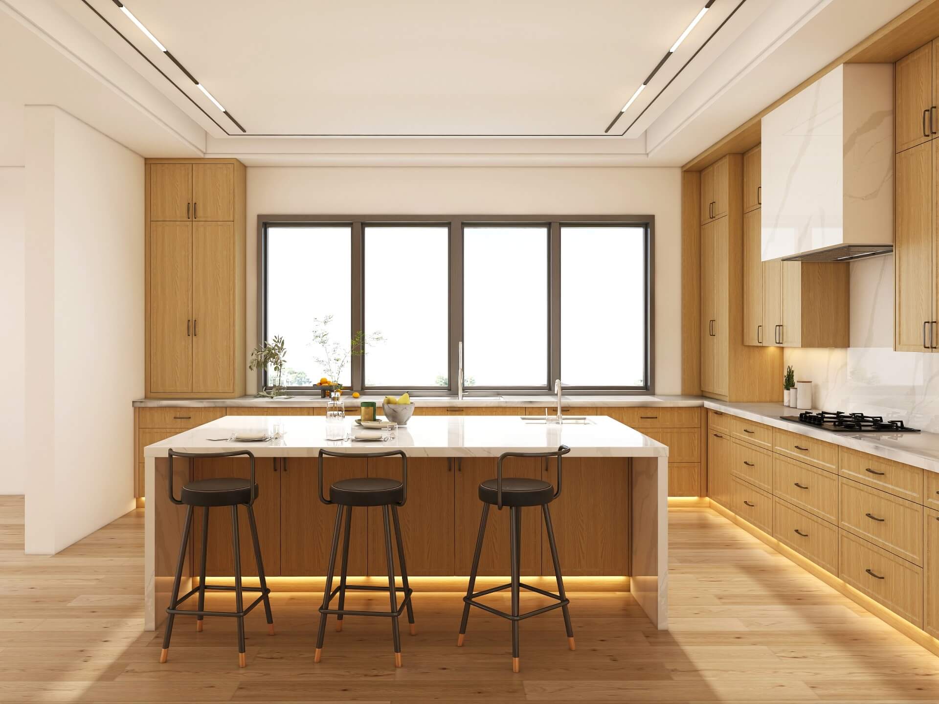 Birch plywood kitchen furniture with quartz island countertop and industrial-style black barstools beneath large windows.