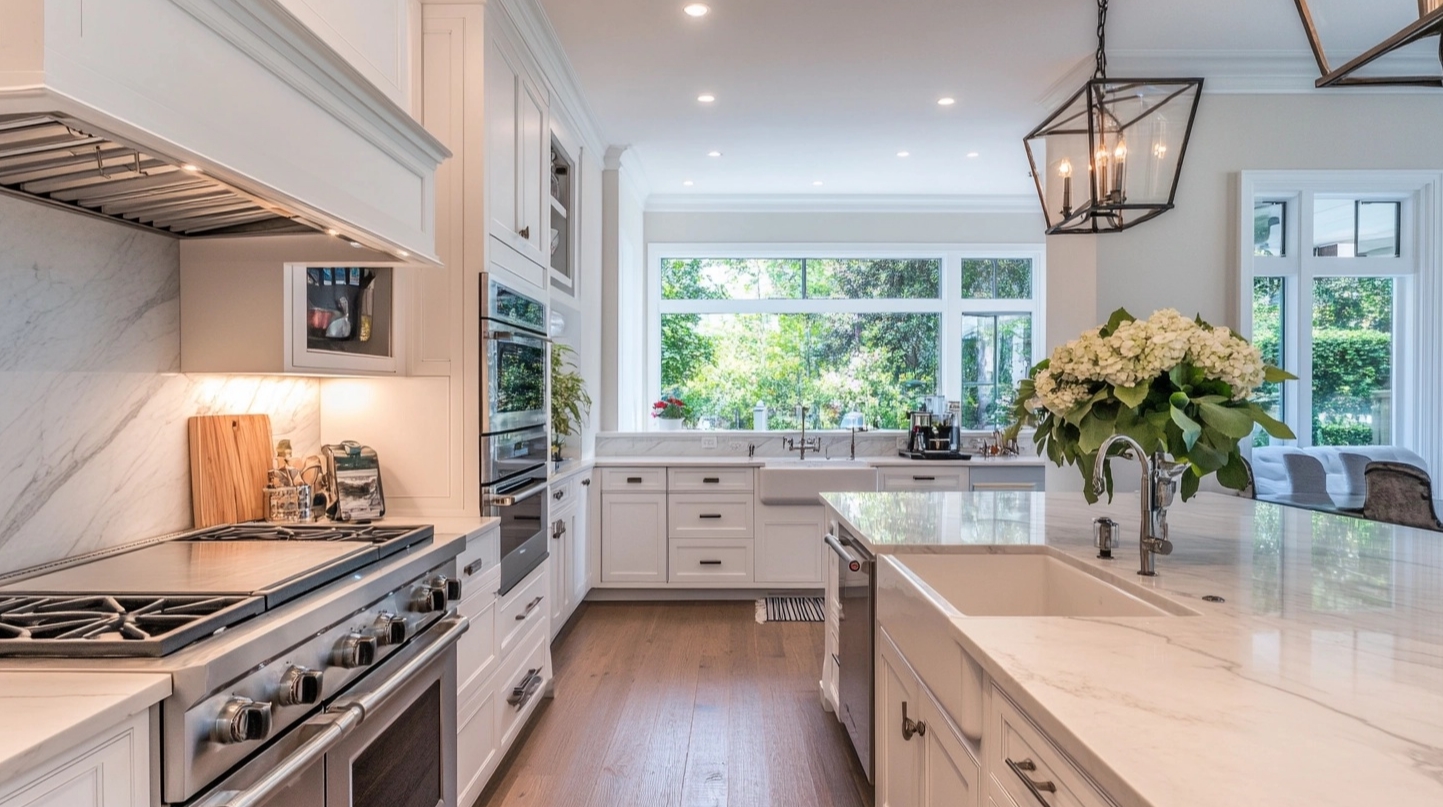 Modern kitchen with white kitchen cabinets bright natural light and spacious marble countertops.