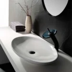Contemporary white vessel sink with black drain and sleek modern faucet design
