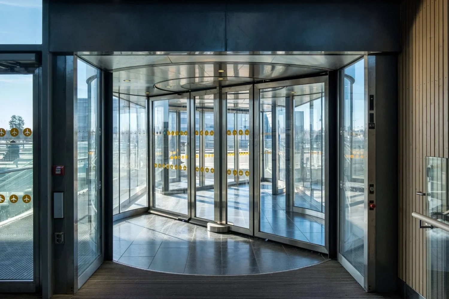 Automatic aluminum door with glass panels installed at a modern commercial building entrance.