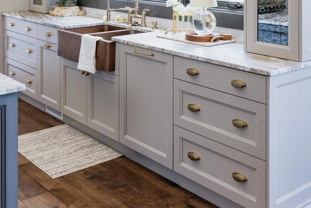 Classic white shaker kitchen featuring round gold cabinet knobs and cup pulls that add soft warmth without overpowering the cabinetry.
